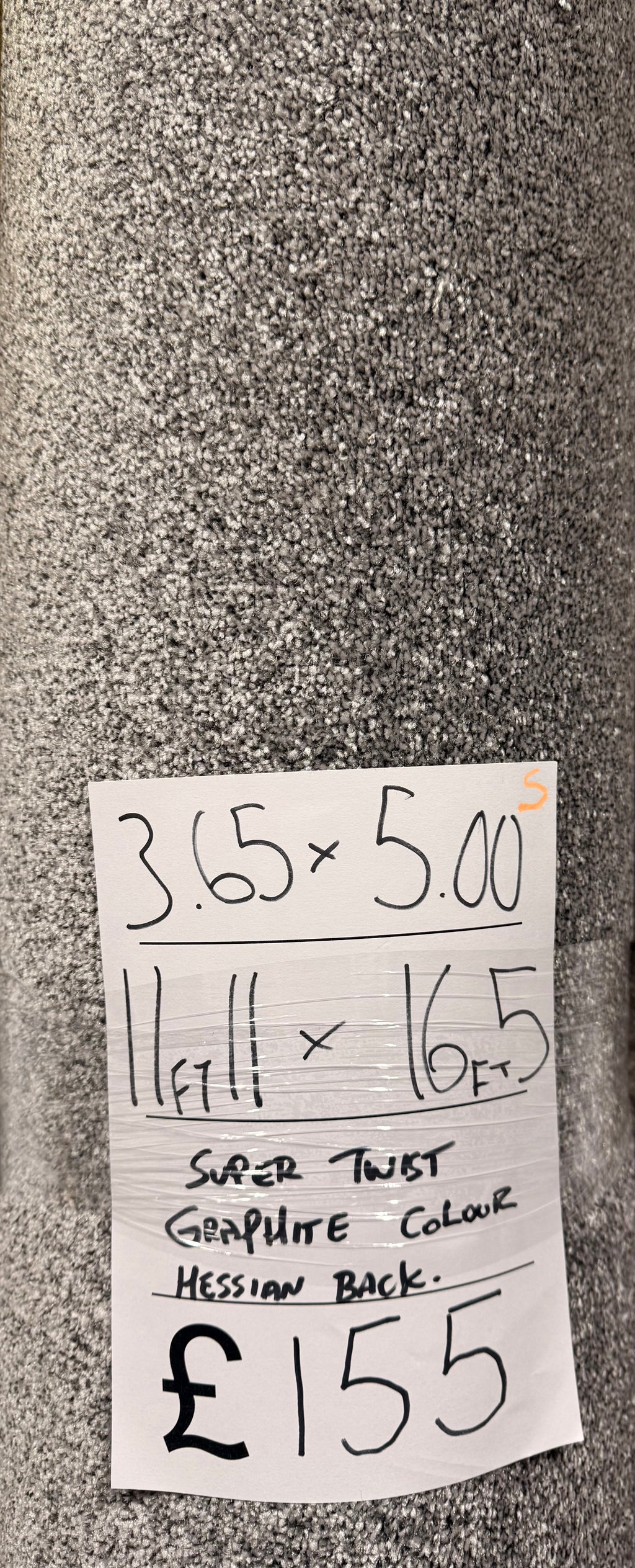 Roll of grey carpet with a price tag attached. Showing a carpet remnant.