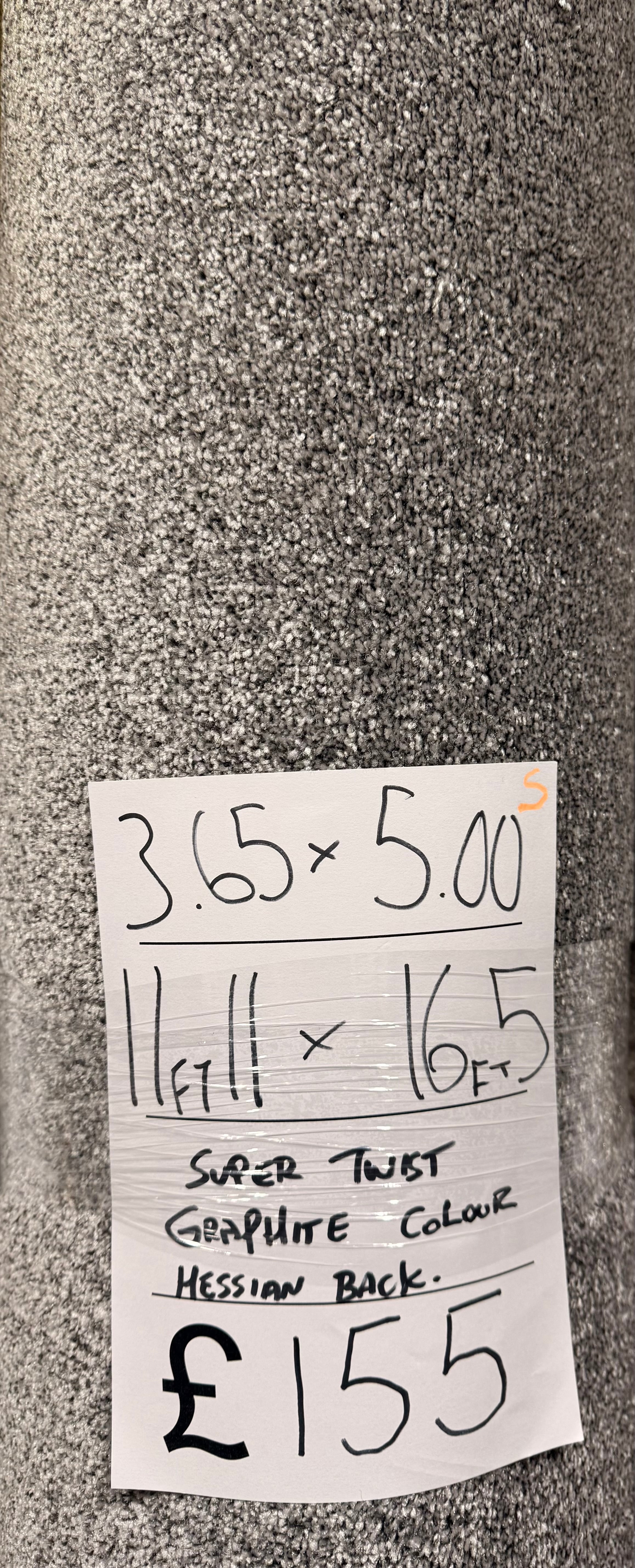 Roll of grey carpet with a price tag attached. Showing a carpet remnant.